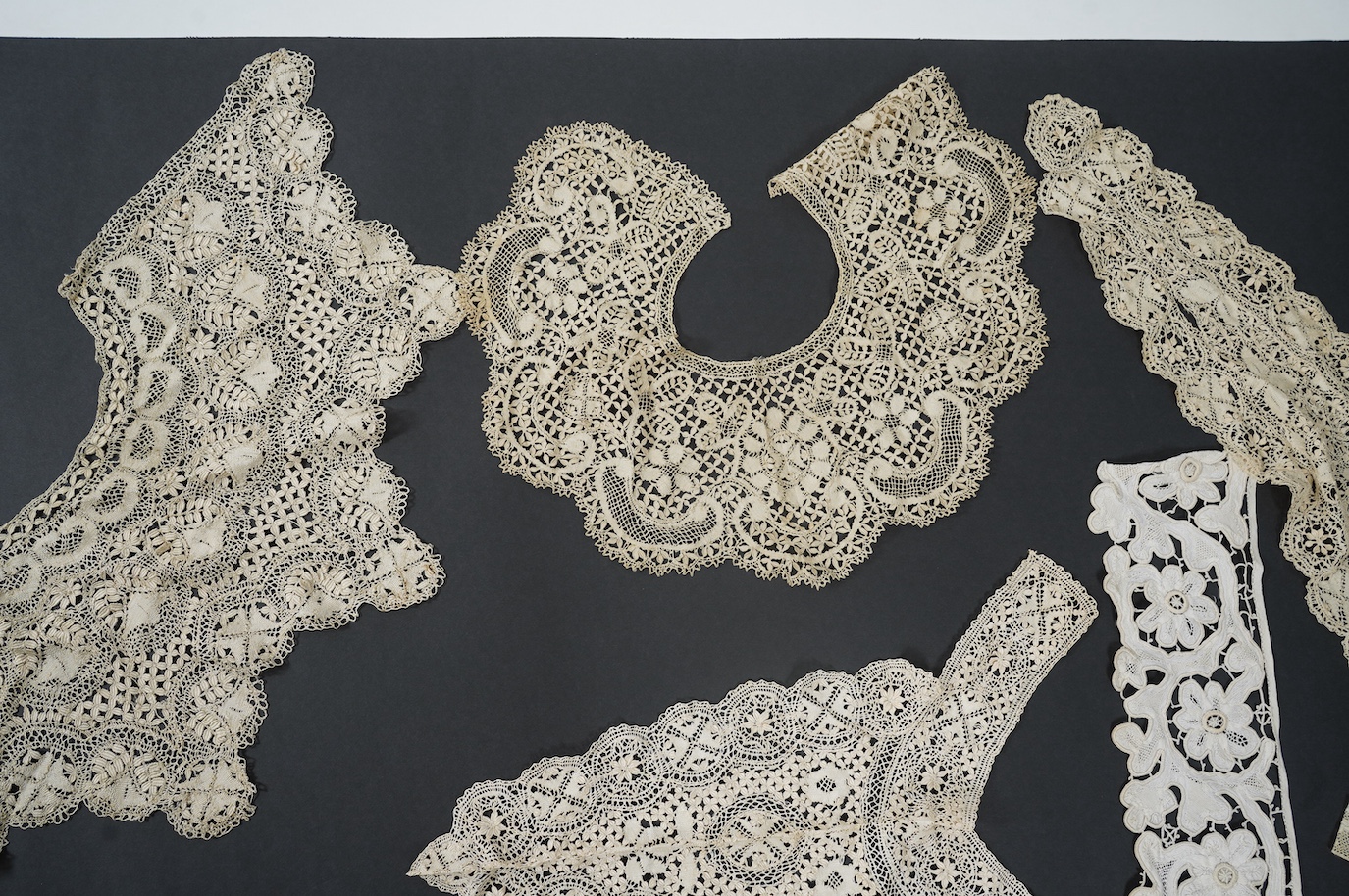 A needle run embroidered net skirt, a similar Bertha, five large silk Maltese bobbin lace collars and trimming, a length of Venetian style lace, mittens etc. Condition - good